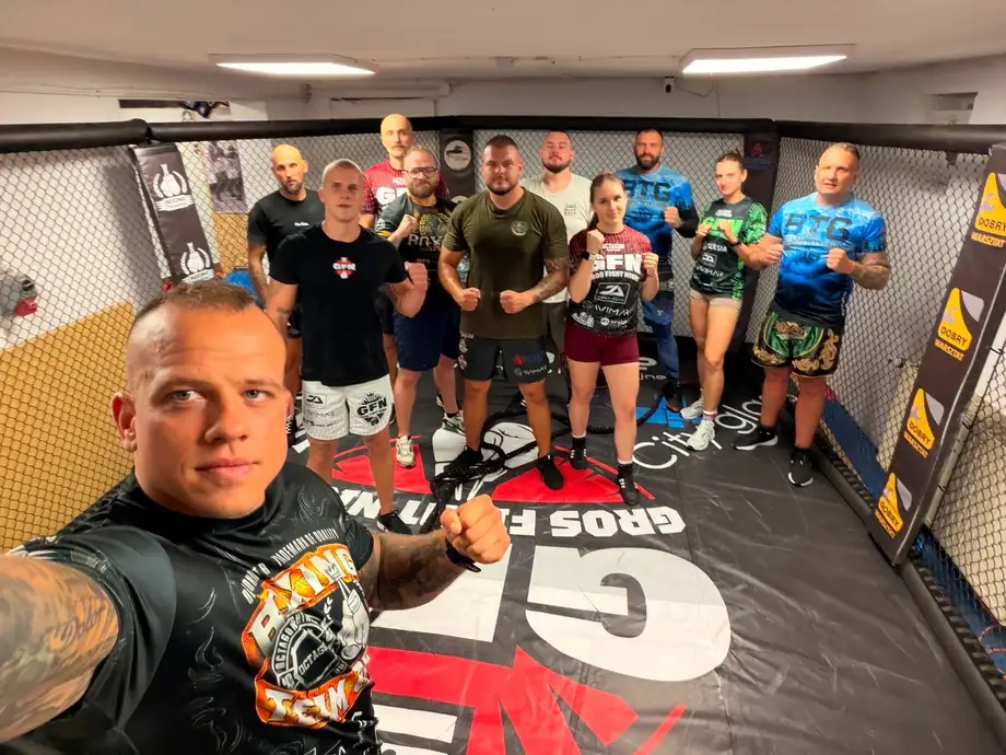 Grupa trenujących w klatce po zajęciach