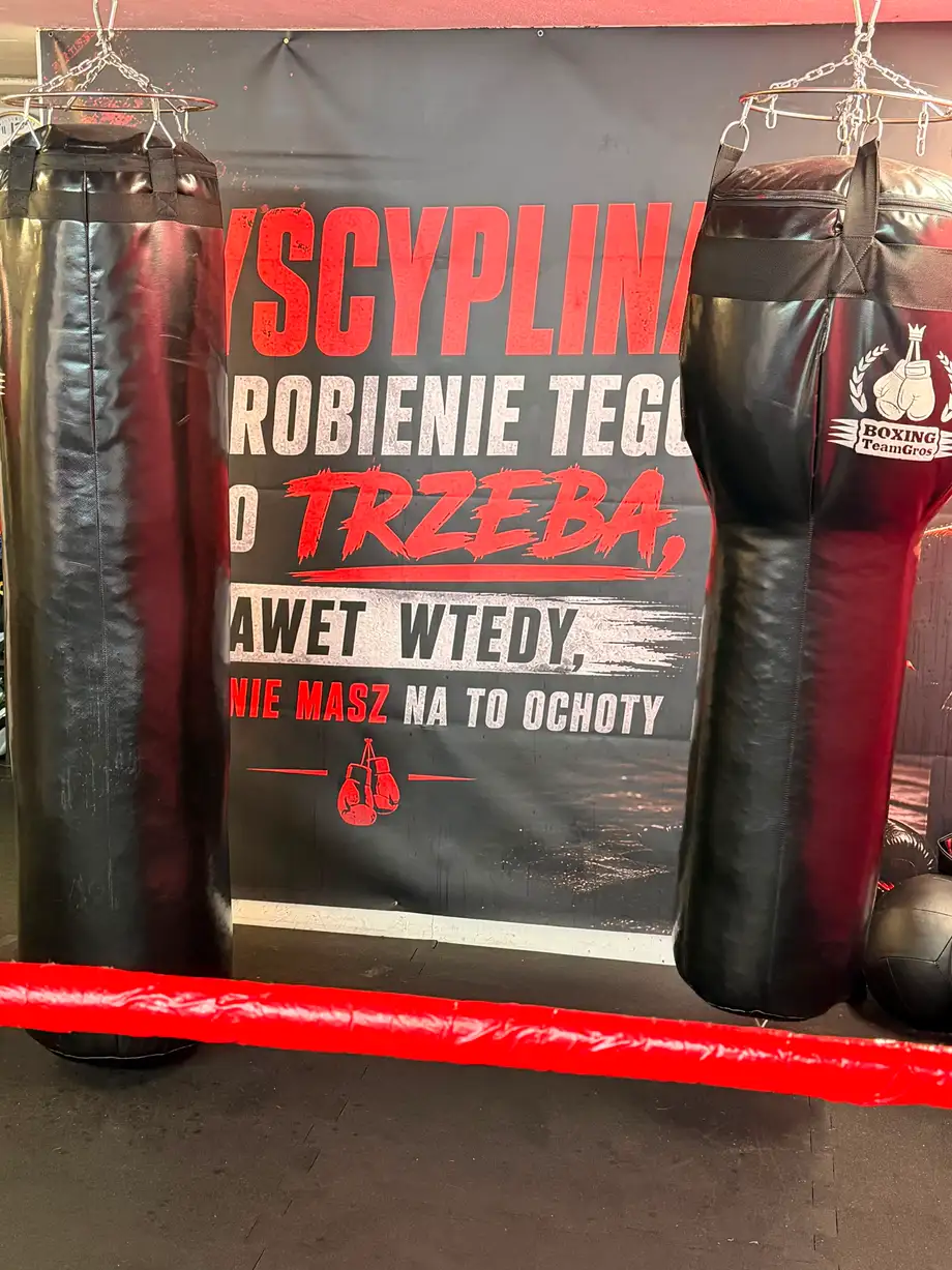 Worki treningowe w sali klubu, w tle baner z hasłem